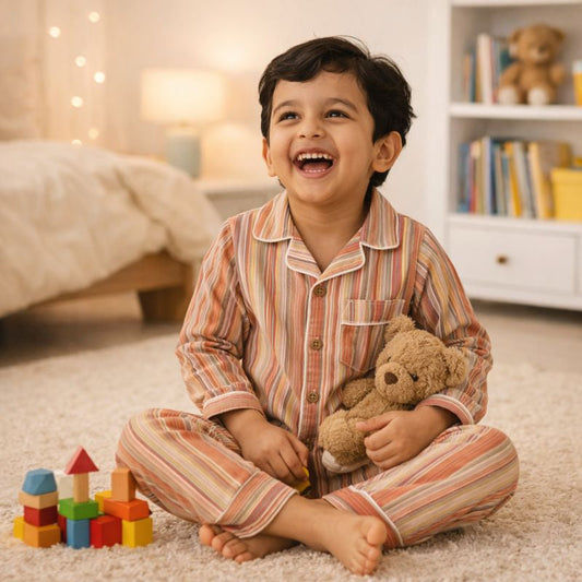 boy enjoying in his room while relaxing with tippy top striped night suit