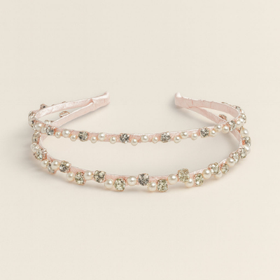 Decorative headband with pearls and crystals on a beige background