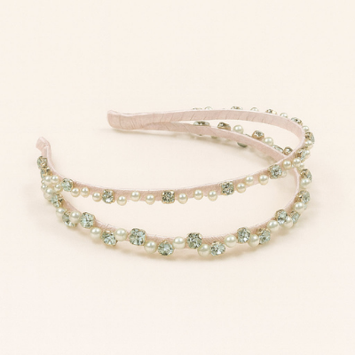 Pink headband with pearl and gemstone embellishments on a light pink background